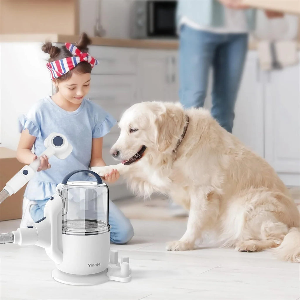Child playing with a toy vacuum cleaner next to a dog in a kitchen.