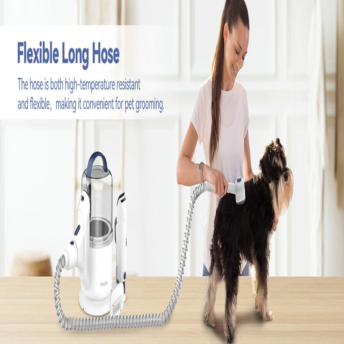Person grooming a dog with a flexible long hose device in a home setting.